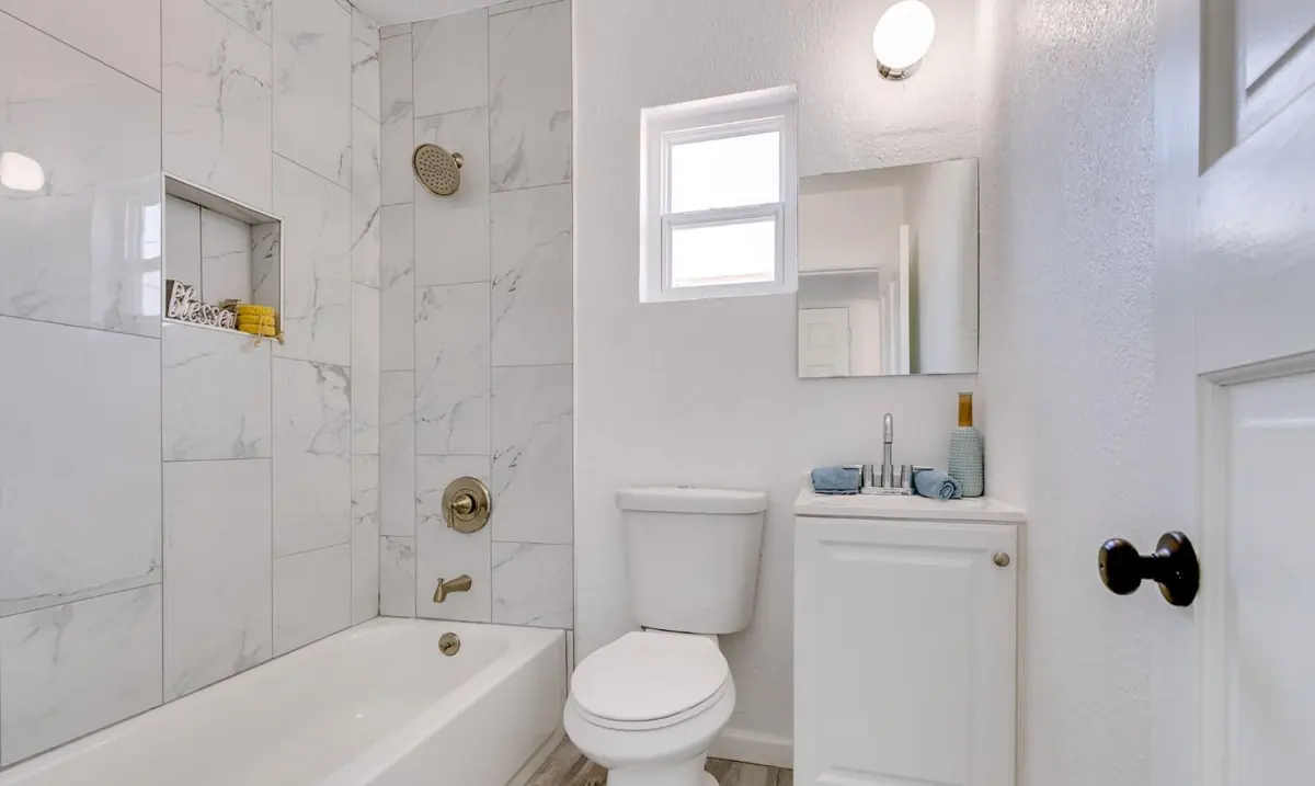 Remodeled white bathroom with new tub and toilet