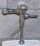 Close-up of a chrome Sloan flush valve